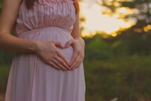 Expecting mother holding her belly for prenatal chiropractic care in Southlake, TX